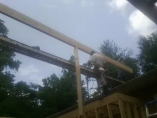 Carpenter setting a ridge beam over a new addition frame — Ice Dam Removal by Roofing Brothers in Saxapahaw