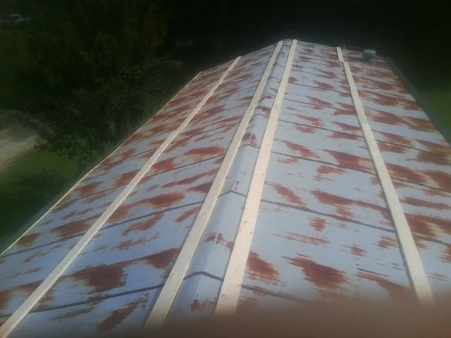Rusted metal roof panels with new wood purlins before replacement — Storm Damage Roof Repair in Saxapahaw by Roofing Brothers