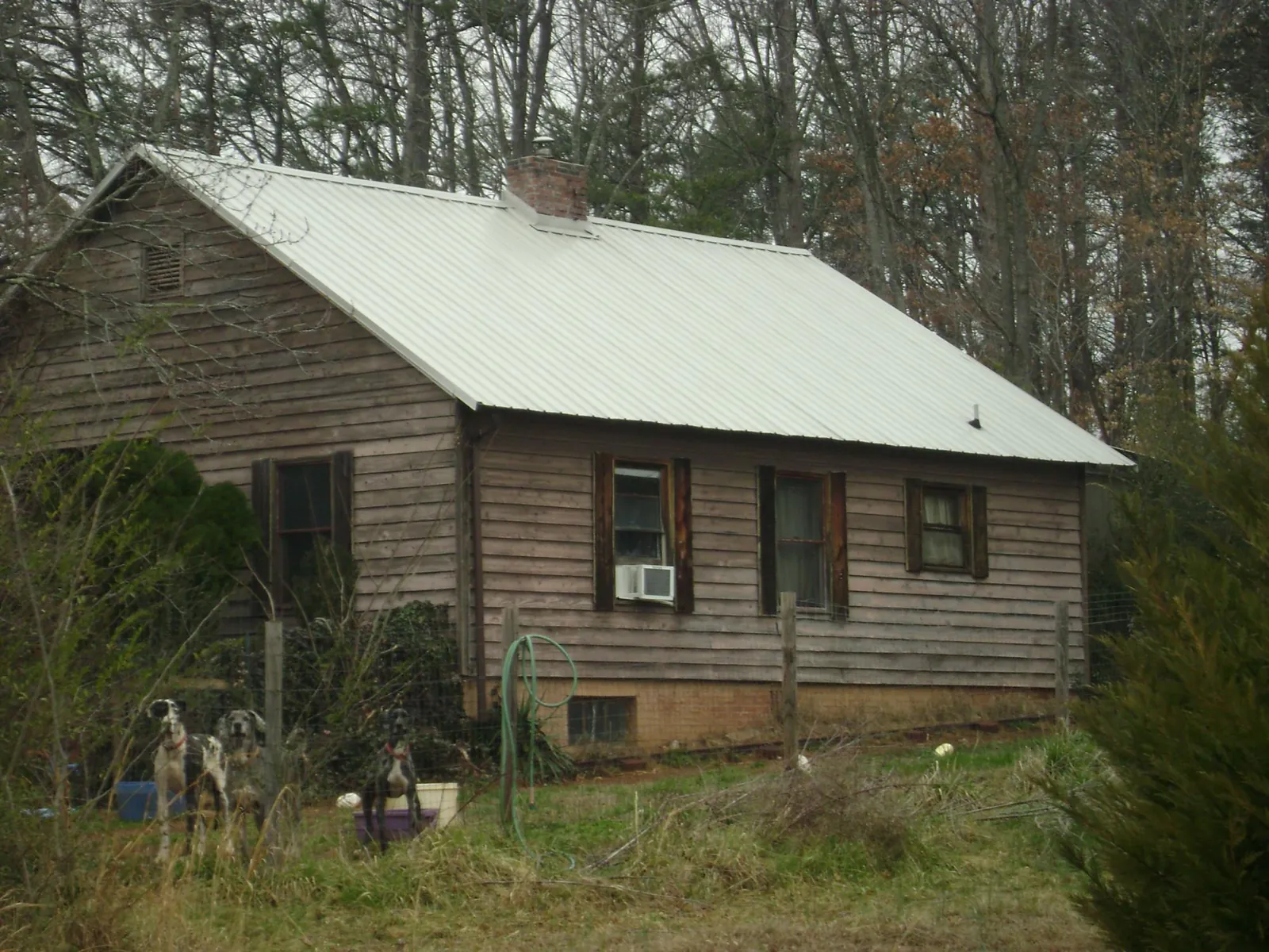 White metal roof on an old wood sided farmhouse, from a Metal Roof Installation job in Saxapahaw